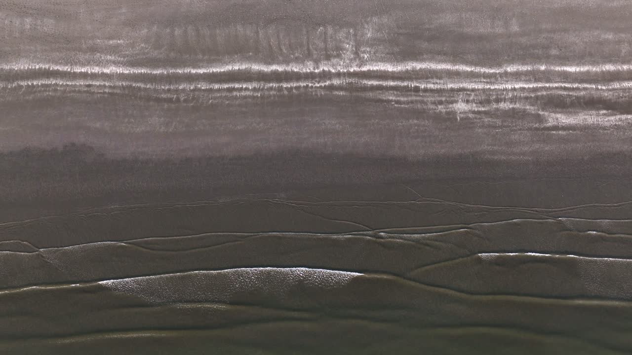 una toma aérea de arriba hacia abajo de la orilla del mar cerca del puerto de ijmuden