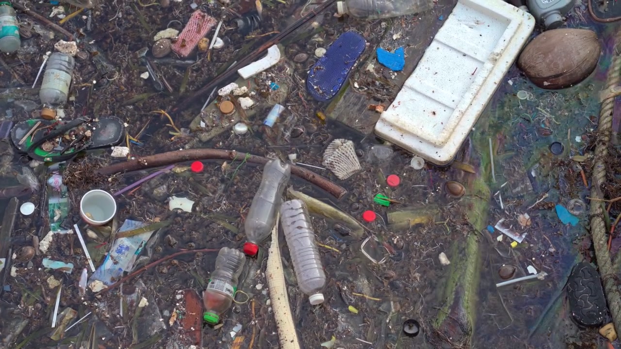 Plastic Waste and Debris Floating in Polluted Ocean Water