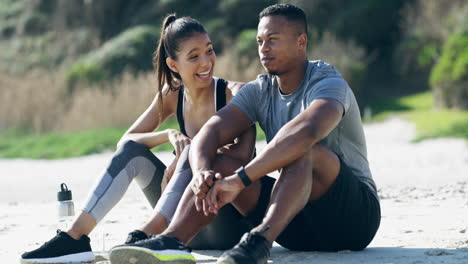 pareja relajándose en la playa después del entrenamiento