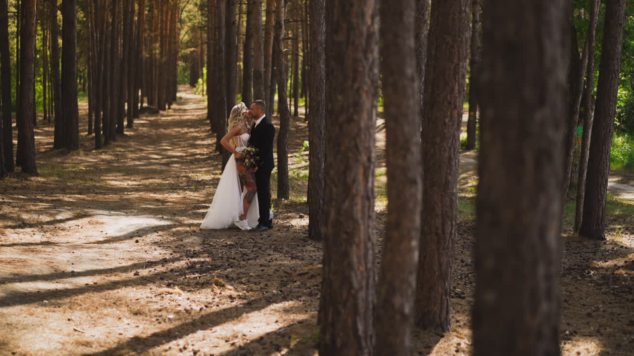 맨 다리에 문신을 한 신부는 공원에서 남편을 키스합니다.