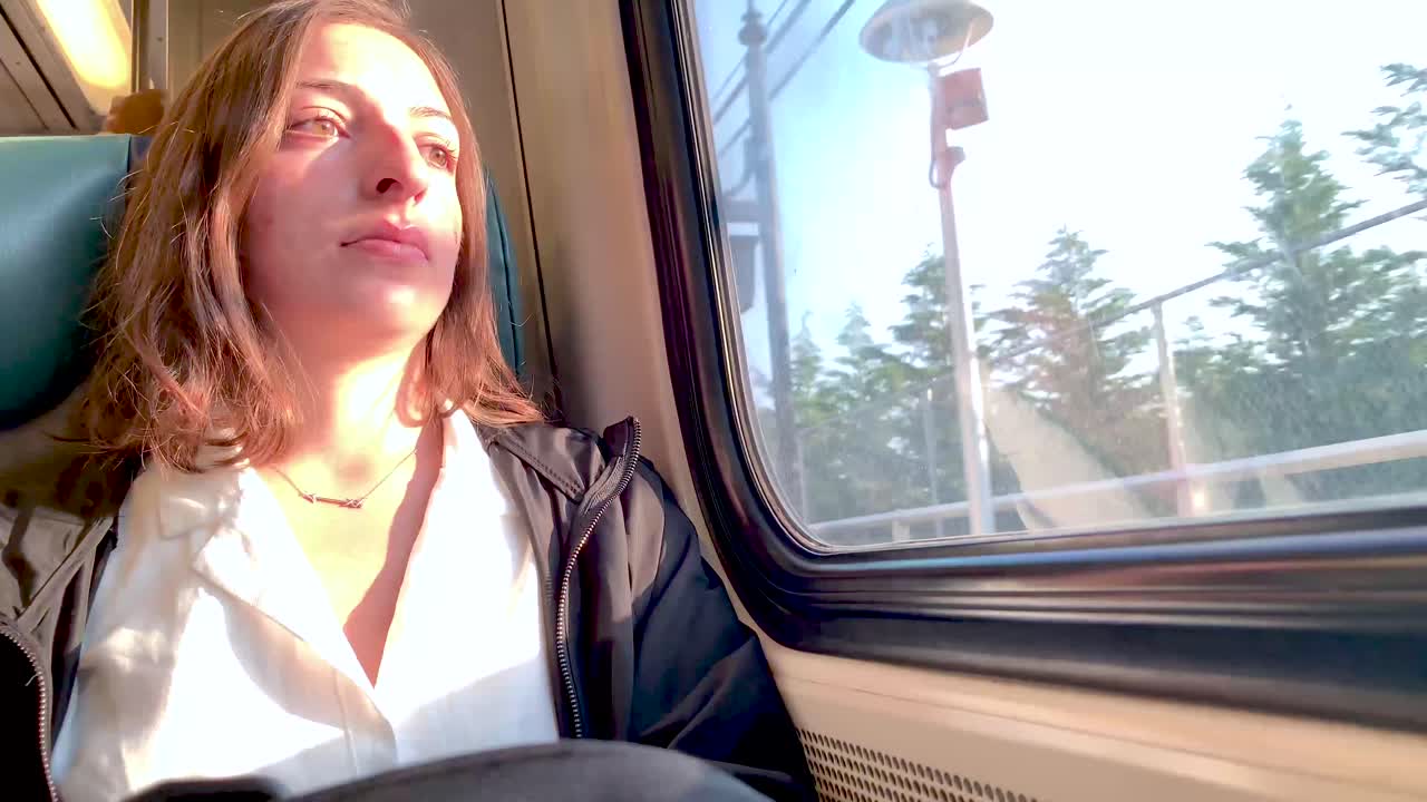 niña sentada en el tren reflexionando sobre su viaje al trabajo