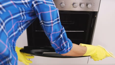 woman front the back cleaning the oven