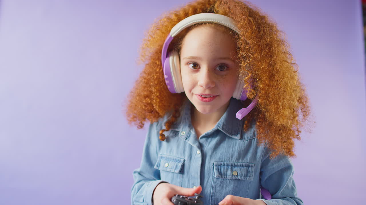 fotografía de estudio de una chica con auriculares jugando con un controlador contra un fondo púrpura
