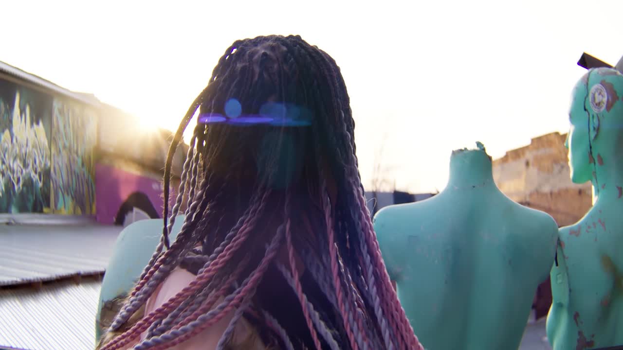 mujer con trenzas en un entorno urbano