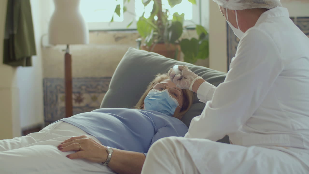 Un medico che misura la temperatura a una donna con un termometro senza contatto.