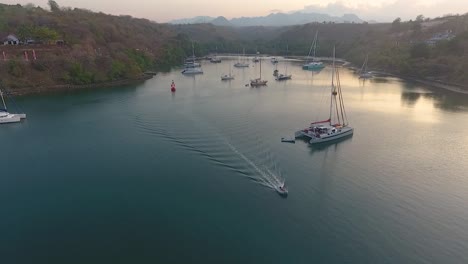 yachts in quiet hidden cove at dreamy sunset in badas harbour, sumbawa island, indonesia