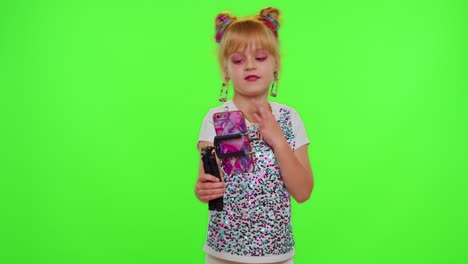Funny-little-kid-girl-blogger-front-of-phone-camera-record-video-enjoy-dance-content-on-chroma-key