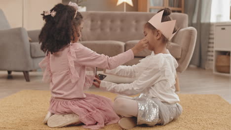 sisters applying makeup to each other