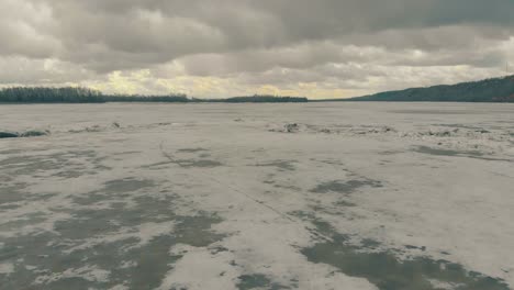 Río-Congelado-Pictórico-Con-Crestas-De-Hielo-Contra-Densos-Bosques