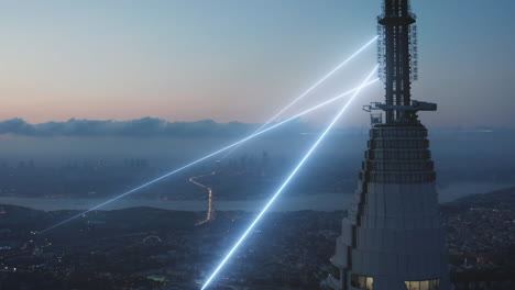 Imágenes-Aéreas-Ascendentes-De-La-Ciudad-Nocturna.-Efectos-Visuales-De-Envío-Y-Recepción-De-Señal-Desde-La-Antena-En-La-Parte-Superior-De-La-Torre-Alta.-Estambul,-Turquía