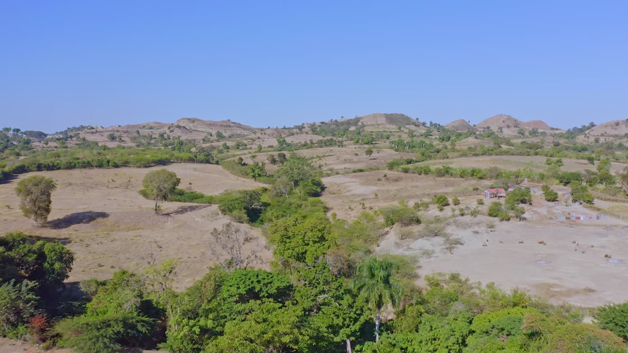 Volo aereo sul paesaggio rurale collinare di Elías Piña e del confine con Haiti durante la luce del sole