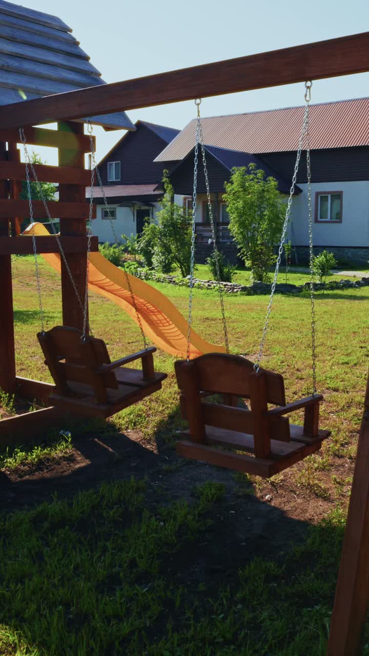 Empty Wooden Swing Set Swaying Gently in a Sunny Backyard