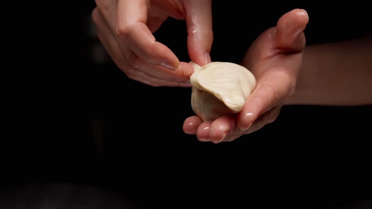 Primo piano di mani che modellano un raviolo tradizionale
