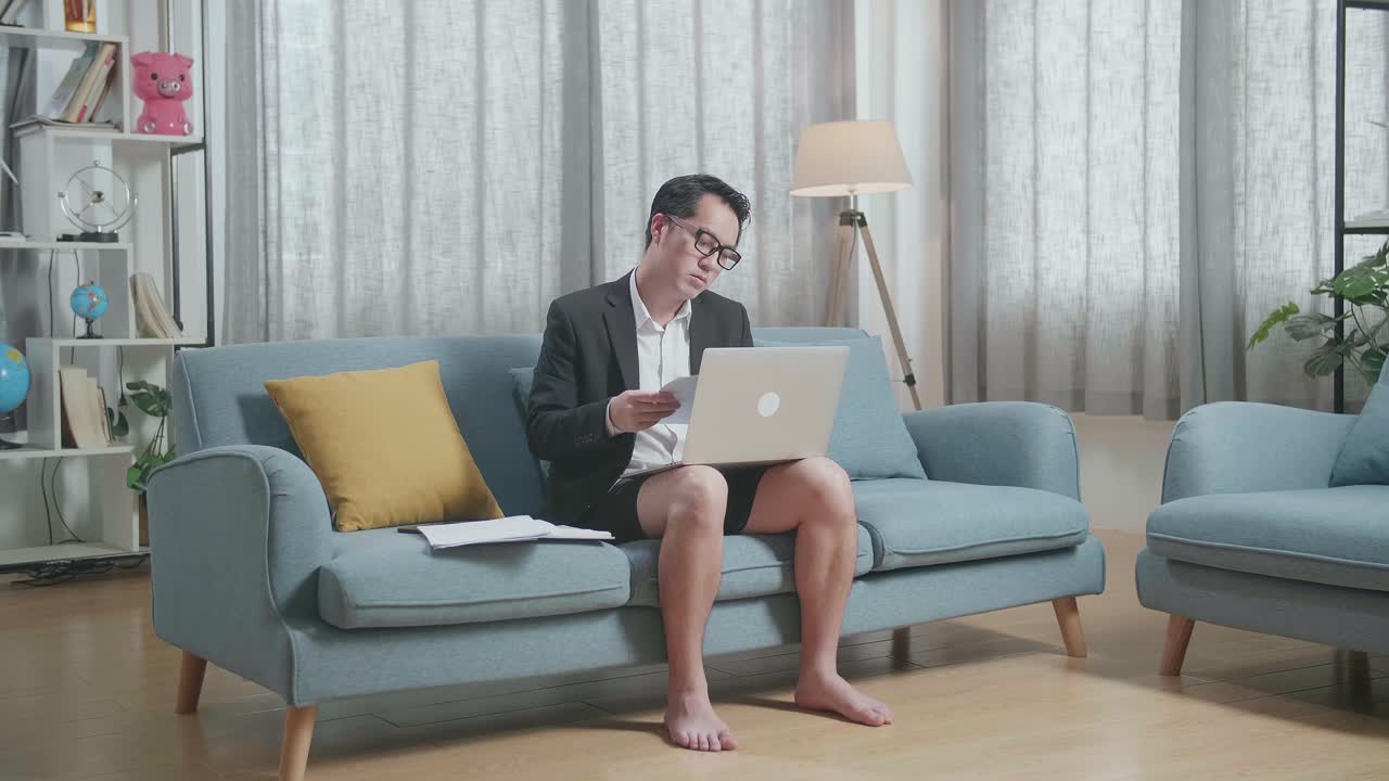 불편한 방식으로 소파에서 집에서 일하는 남자