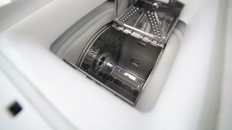 woman hands puts clothes in the washing machine woman puts clothes in the washing machine hands hold a white towel