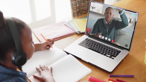 Composition of african american schoolgirl on laptop online learning with african american schoolboy