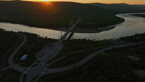 Drohne-Steigt-In-Richtung-Der-Sami-Brücke-Und-Des-Tenojoki-Flusses-Auf,-Mitternachtssonne-In-Utsjoki,-Finnland