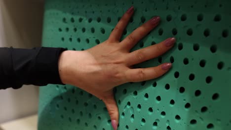 hand pressing into a green porous foam material