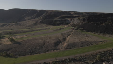 AERIAL-DRONE-SHOT-OF-SUN-LAKE-DRY-FALLS-PARK-LANDSCAPE-AND-MOUNTAINS