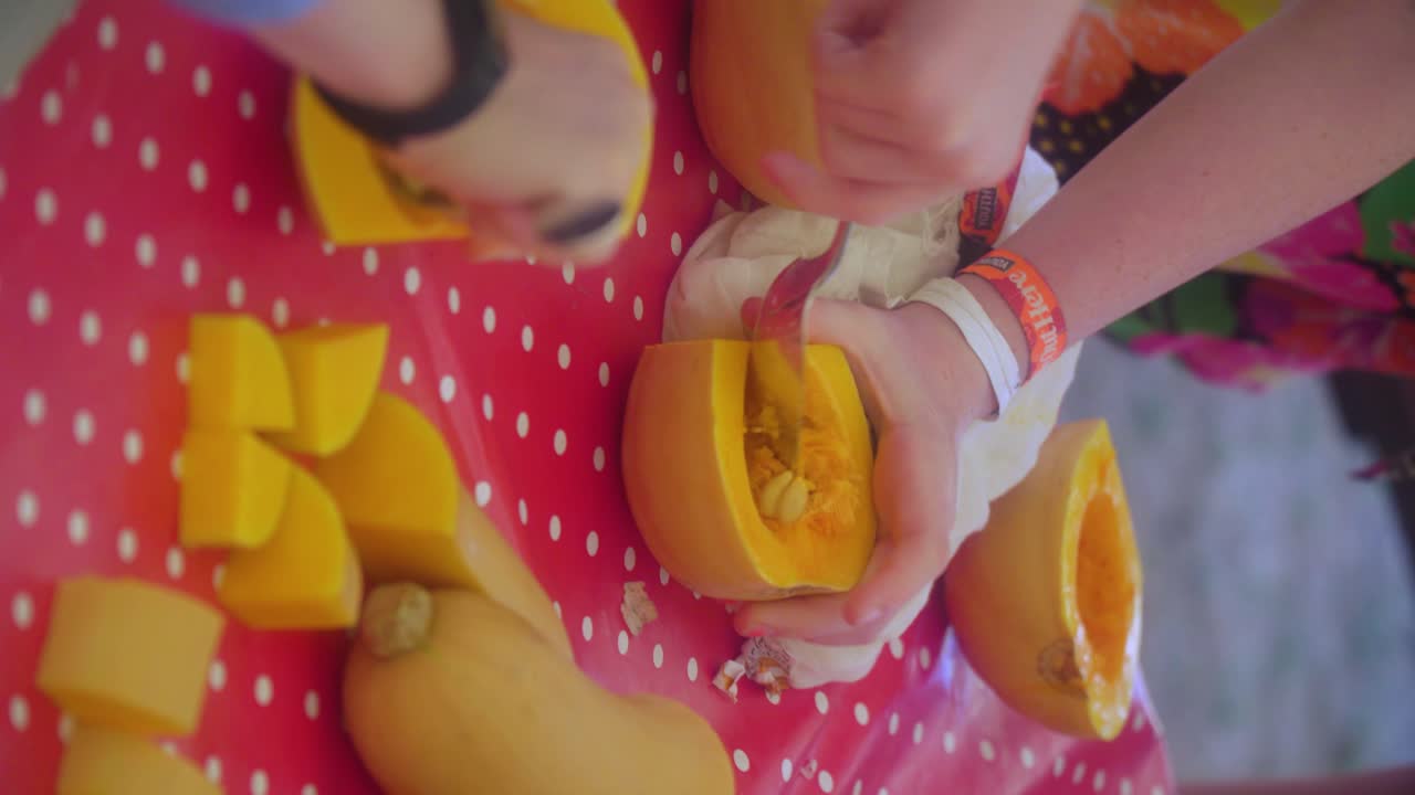los jóvenes chefs están sacando las semillas en la clase de cocina de la calabaza para preparar una sopa para sus padres en el festival de música de verano cerrar las manos vista vertical
