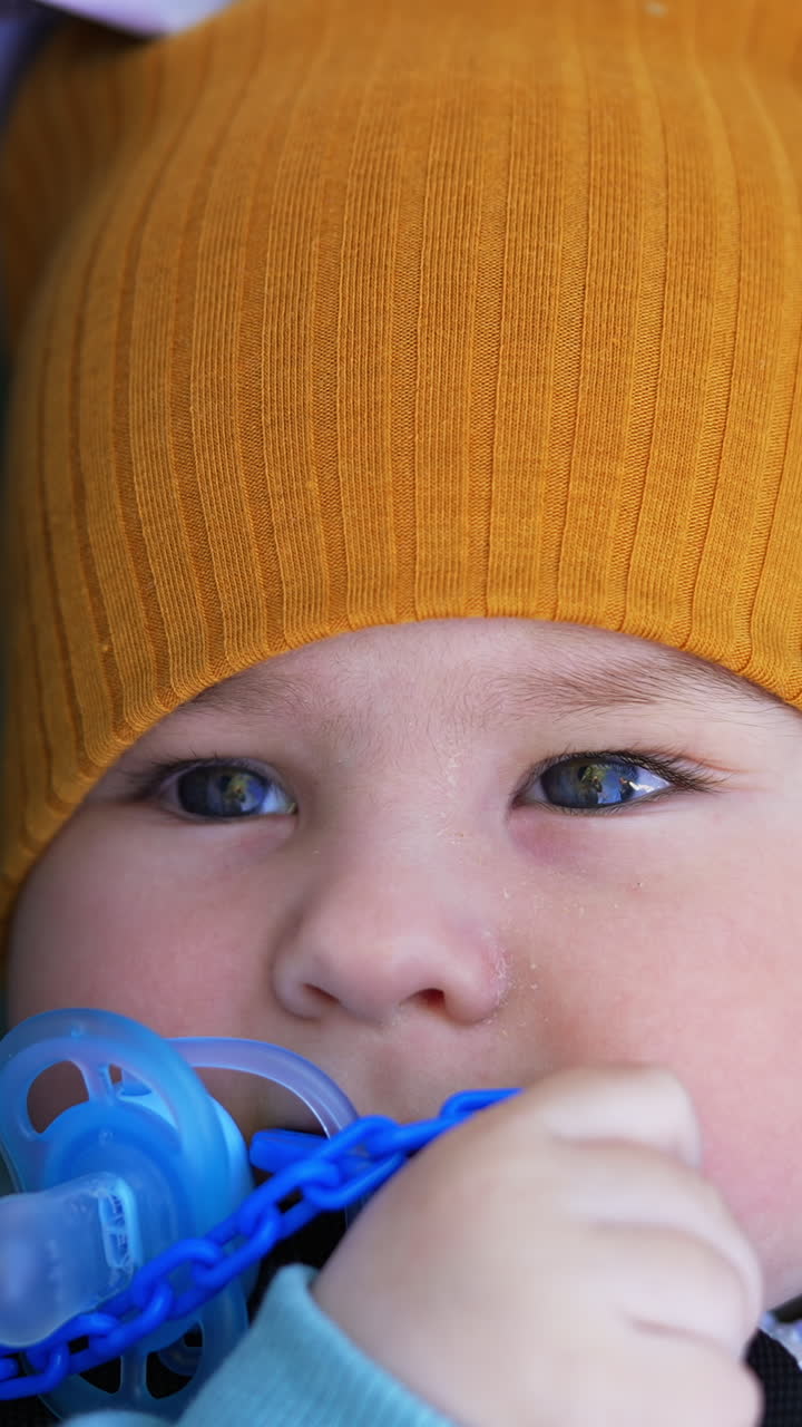 Baby with Pacifier and Orange Hat
