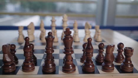 Pan-Left,-Chess-Board-with-Wooden-Black-Pieces-and-Soft-Focus-White-Set