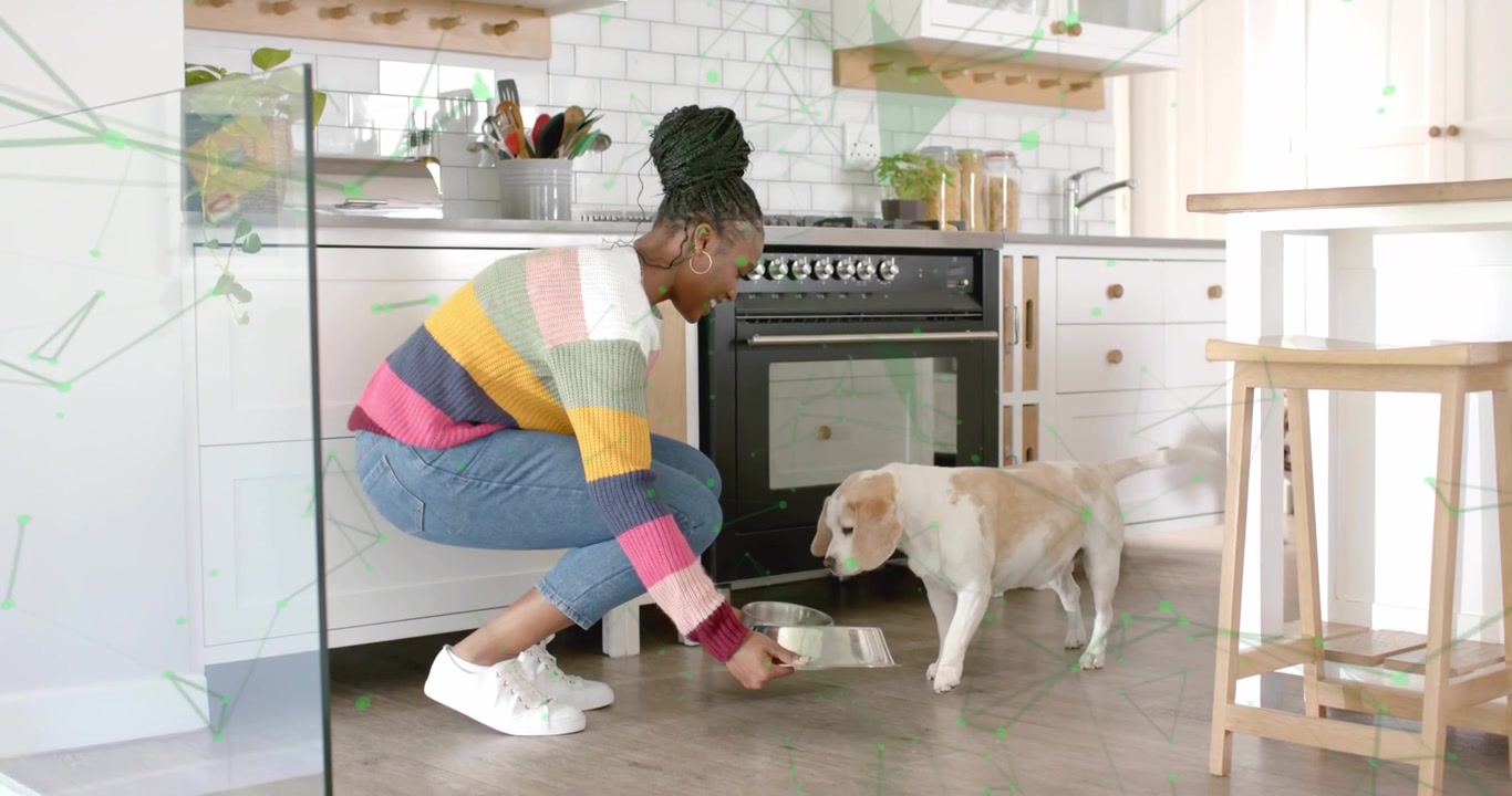 Donna che solleva una ciotola per cani in acciaio inossidabile in una cucina domestica, cucciolo che esce dal forno per l'alimentazione e la cura dell'animale domestico.