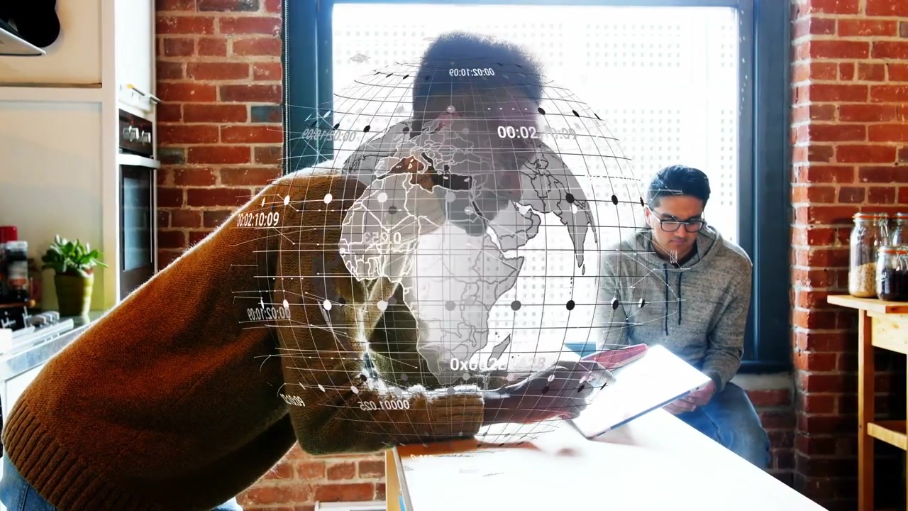 Standing man tapping tablet in loft kitchen, generating hologram globe overlay for tech data review