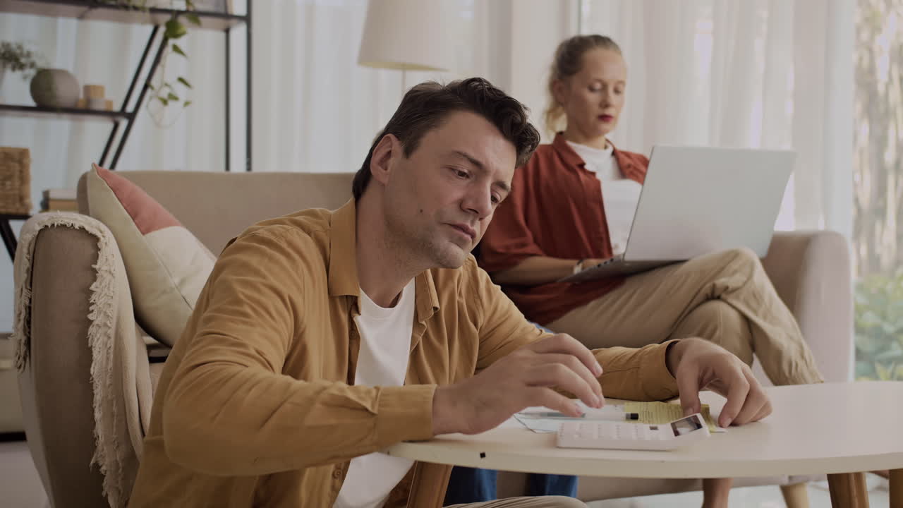 Man Telling His Wife about High Utility Bill at Home