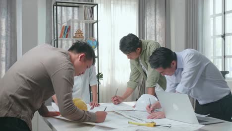 group of asian engineers drawing building construction at the office