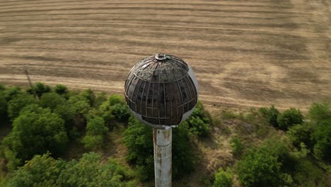 Antigua-Torre-De-Agua-Destruida-Abandonada,-Toma-Aérea-En-órbita,-Verano,-Europa