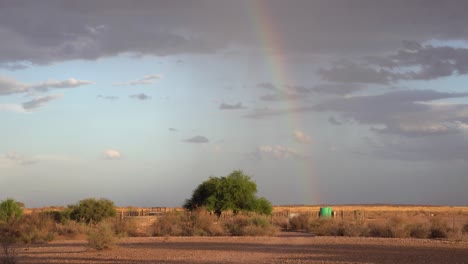 Toma-Todavía-Estable-De-Un-Arco-Iris-En-La-Distancia,-Con-Un-Recinto-De-Ovejas-Al-Frente-En-Una-Granja-De-Ovejas-En-Namibia