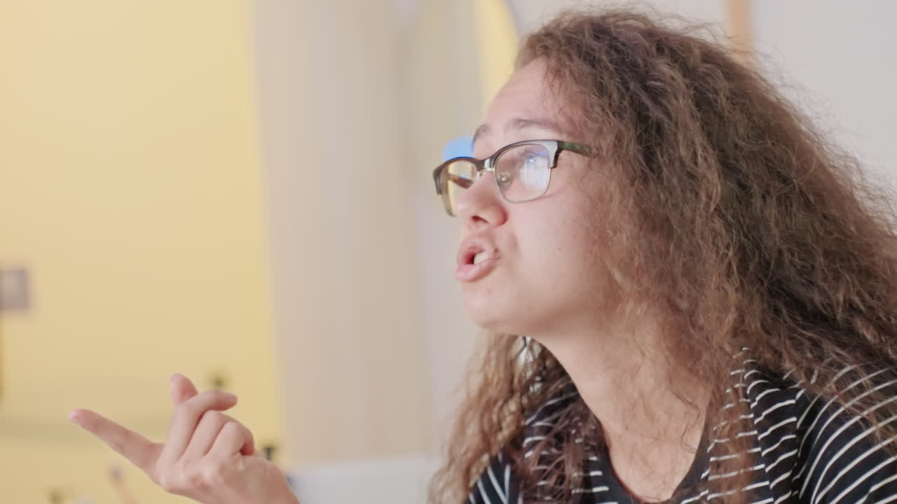 Client d'hôtel dans la salle de bain inspectant sa peau, touriste solitaire en chemise rayée et lunettes se regardant dans le miroir avec une expression tendue, douce lueur de lampe, lavabo et articles de toilette visibles, gros plan de profil révélant de subtils détails.