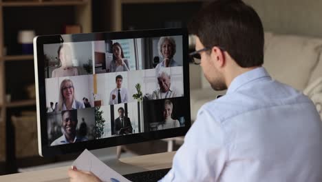 over shoulder view male worker meet colleagues online at videoconference