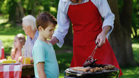 father and son preparing food on barbecue