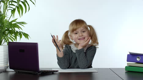 preschool child girl distance online learning at home. kid studying using digital laptop computer