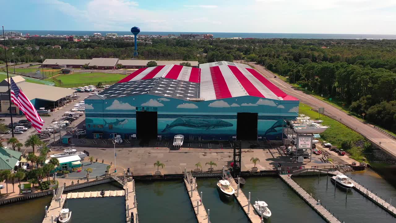 지붕이 미국 국기로 칠해진 데스틴 플로리다의 전설적인 해병에서 멀리 날아가는 드론 뷰는 신의 축복이 미국에 있다고 말합니다