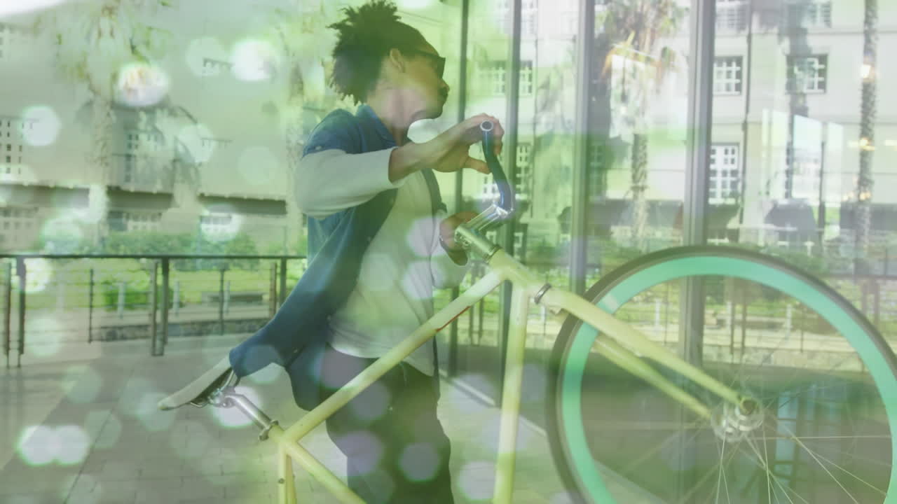 animación de puntos de luz sobre un hombre biracial que lleva una bicicleta