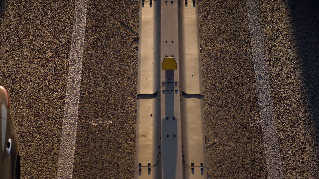 아침 빛에 고속도로를 운전하는 자동차 드론. 고속도로 충돌 장벽 뷰.