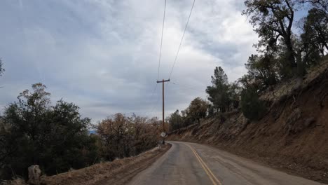 conduciendo a lo largo de un camino sinuoso en las montañas y estribaciones de tehachapi, california - vista de la ventana trasera