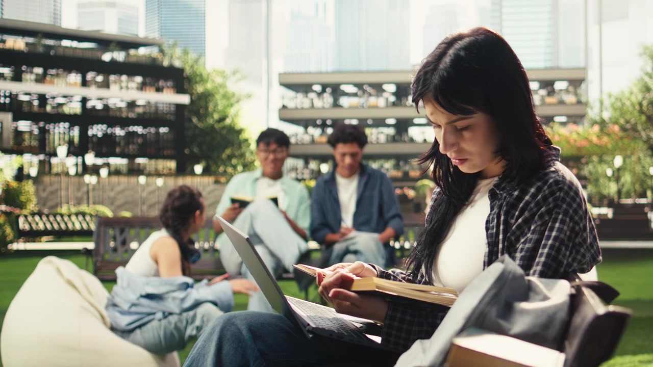 Focused woman student working on laptop while sitting on bench