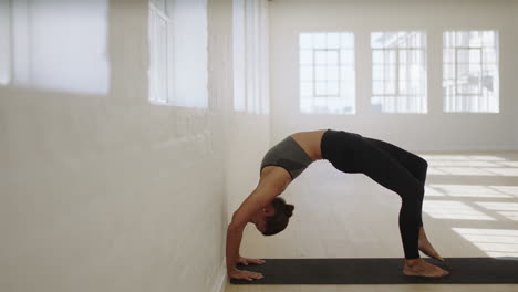 healthy yoga woman practicing upward bow pose enjoying fitness lifestyle exercising in studio stretching flexible body training on exercise mat