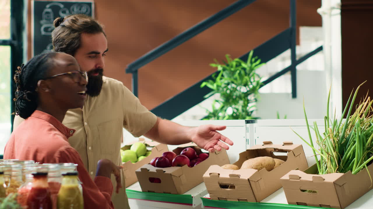 상인이 고객에게 채소를 보여줍니다.