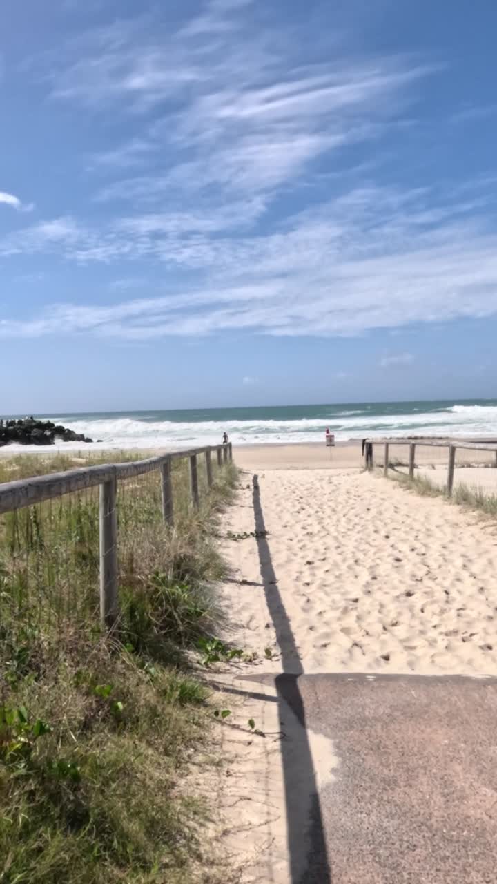 camino a la playa con la torre de socorristas visible