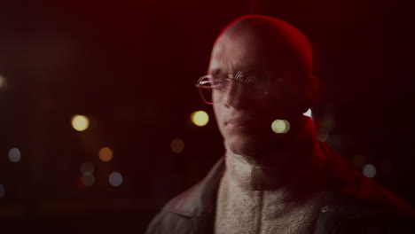 man with glasses in red light at night