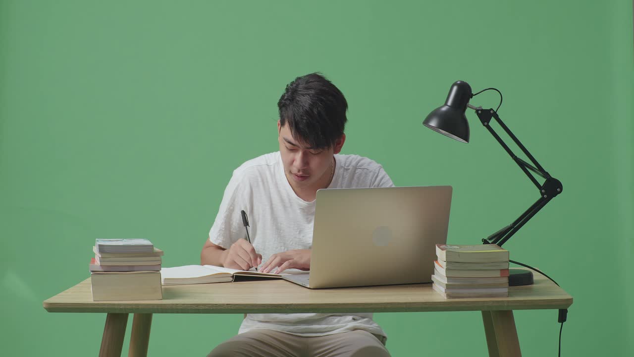 노트북과 책으로 공부하는 학생