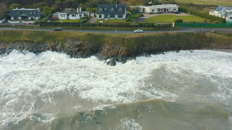 Aerial-view-of-waves-crashing-against-rocks-along-the-coastline-during-a-storm