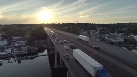 Drohnenschuss-Beim-Zurückfahren-über-Die-Interstate-Auf-Der-Brücke-Bei-Sonnenuntergang,-Mit-Starkem-Verkehr