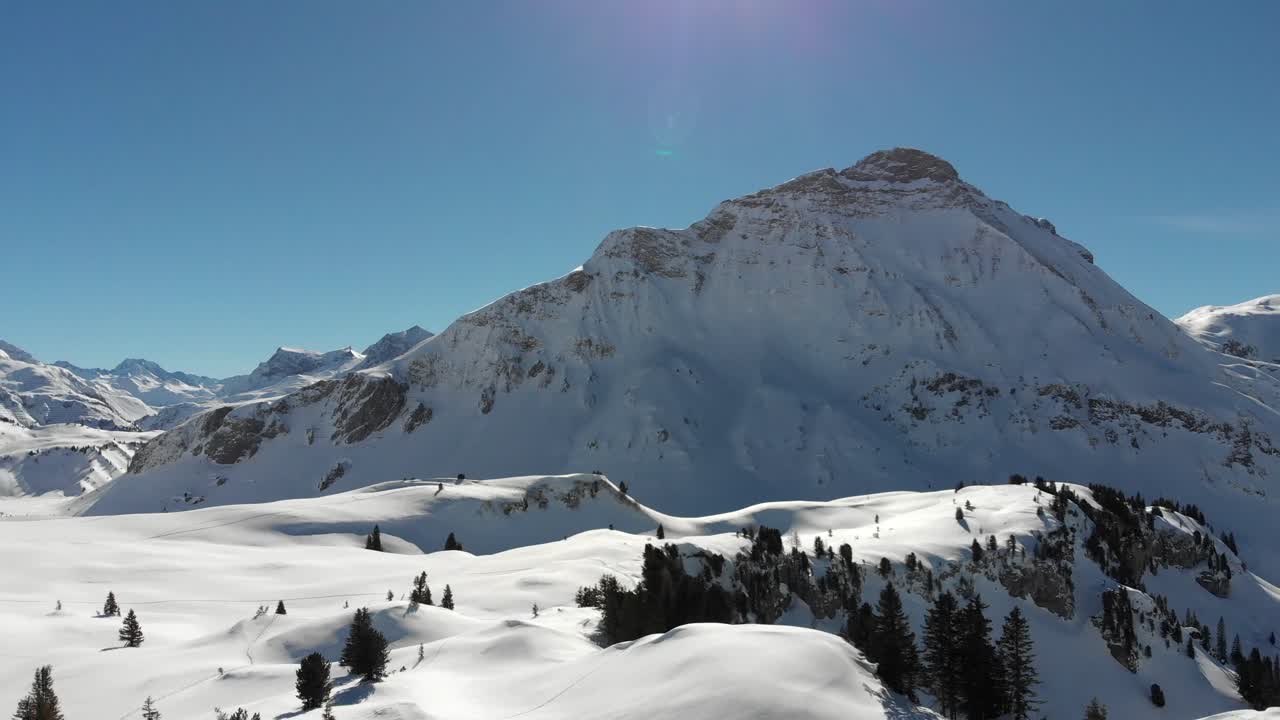 Panoramic drone view of many snow-covered mountain ranges in Warth, a small municipality in Vorarlberg, Austria on a beautifully clear and sunny day in 4K