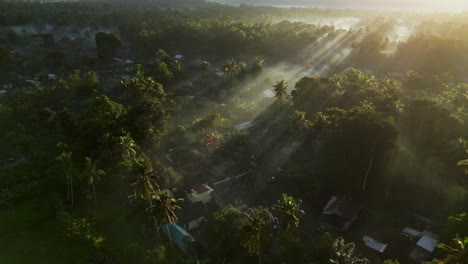 Drohne-Fliegt-Bei-Sonnenaufgang-über-Ackerland-Und-Einem-Kleinen-Dorf